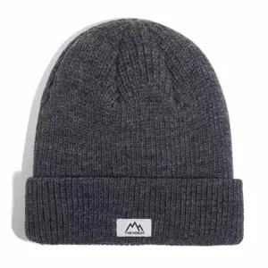 Dark grey knit beanie hat for men and women, warm winter thermal fleece ski cap with woven label.
