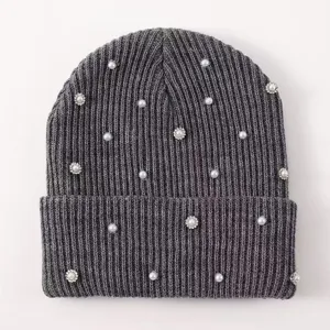 Close-up knit beanie texture with elegant pearl and sparkling rhinestone embellishments.