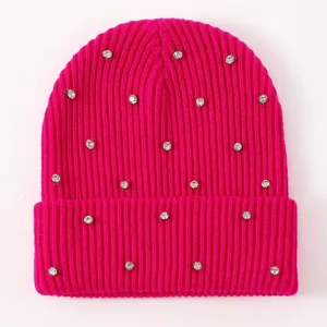 Rhinestone embellished hot pink knit beanie detail, sparkly crystal decorated winter wool hat close-up