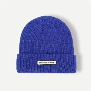 Classic royal blue knit beanie winter warm hat with stylish front beige cloth tag detail.