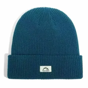 Winter warm knitted beanie hat with stylish front patch, casual solid color thermal cap.