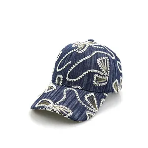 Detailansicht der dunkelblauen Jeans Baseballkappe mit weißer Pailletten Stickerei.