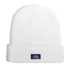Close-up view of white knitted beanie hat with custom blue woven patch featuring mountain logo.