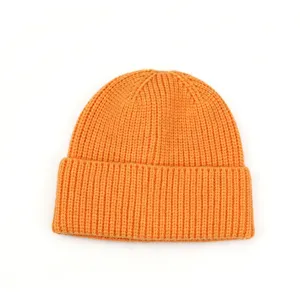 Gros plan sur le bonnet en tricot orange vif, montrant la texture fine et les détails du revers.