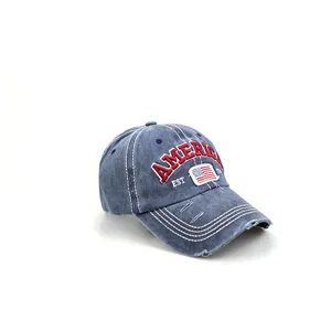 Close-up detail of washed denim baseball cap with AMERICA embroidery and distressed brim.