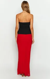 Detail view of the stylish black strapless top and red maxi bodycon skirt showing texture.