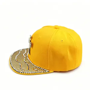 Gros plan détaillé d'une casquette jaune avec un emblème de croix et une visière cloutée.