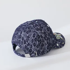 Vue détaillée de la casquette de baseball en dentelle bleu foncé avec strass étincelants et boucle.