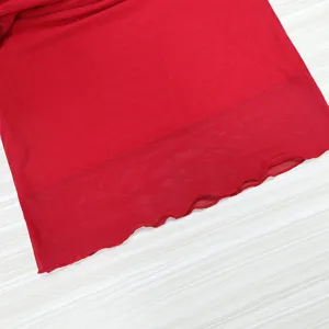 Red mesh skirt hem detail close up, double layer sheer fabric, elegant summer apparel.
