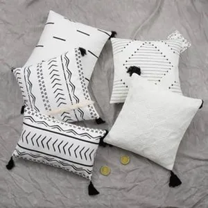 Housses de coussin géométriques noires et blanches bohèmes avec pompons, idéales pour canapé.
