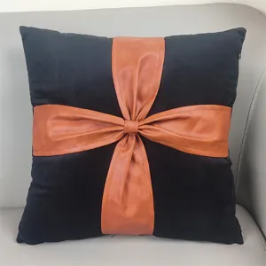 Black velvet throw pillow with brown faux leather bow knot design, modern decorative sofa cushion.