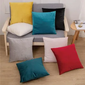 Vue détail des housses de coussin en velours unies, texture douce, déco de maison.