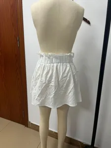 Detailed view of the white mini skirt featuring a stylish elastic ruffled high waist design.