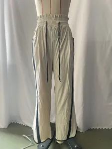 Detailopname van casual losse trekkoord broek met contrasterende zijstrepen en elastische taille.
