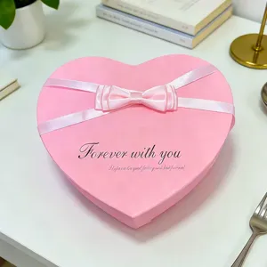Rosa herzförmige Geschenkschachtel mit weißer Schleife, ideal für Valentinstag und Geburtstag.