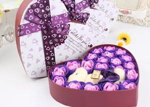 Detailaufnahme der herzförmigen Seifenrosen-Geschenkbox mit Plüschbär und großer Schleife.