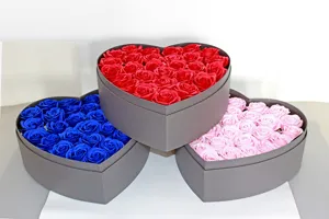 Dettaglio della confezione regalo di rose di sapone a forma di cuore con fiori rossi e blu.