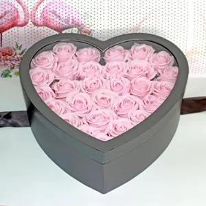 Scatola regalo nera a forma di cuore riempita con bellissime rose di sapone rosa per regali.