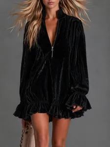 Detailed view of the black velvet dress, featuring a half-zip mock neck and ruffled sleeves.