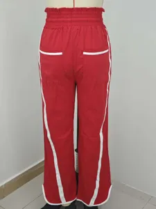 Gedetailleerd overzicht van rode casual broek met witte biezen en hoge tailleband.