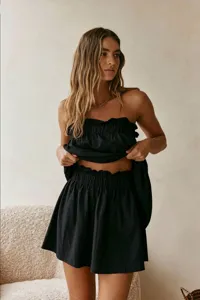 Black strapless top and ruffled mini skirt detail set, casual vacation style for summer.