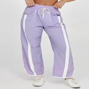 Losse paarse joggingbroek met witte bies aan de zijkant en handige verstelbare trekkoord.
