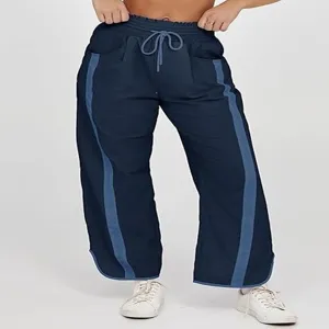 Gedetailleerd overzicht van losse casual damesbroek met trekkoord en contrasterende zijstrepen.