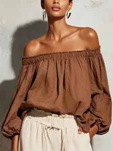 Close-up detail of the elegant brown off-the-shoulder blouse featuring long lantern sleeves.