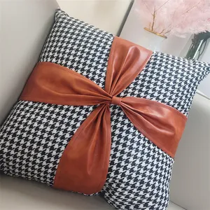 Houndstooth throw pillow with brown leather bow detail, decorative cushion for sofa.