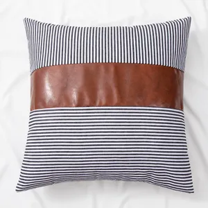 Close-up detail of the American style throw pillow featuring black white stripes and brown leather.