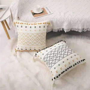 Housse de coussin bohème en pur coton tissé avec pompons pour décoration de salon et canapé.