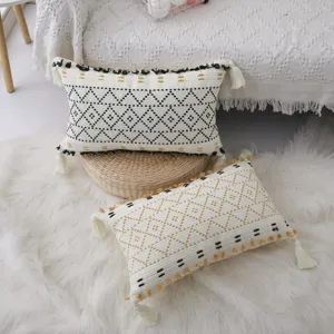 Coussin décoratif bohème tissé en coton avec pompons pour canapé et lit salon.