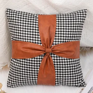 Black and white houndstooth throw pillow cover with brown faux leather bow accent main view
