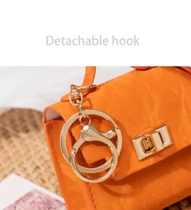 Miniatur Handtaschenanhänger Detail zeigt goldenen Drehverschluss und abnehmbaren Haken.