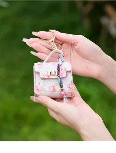 Detailansicht der mini Blumen-Schlüsselanhänger Tasche mit Rosenmuster und Tuch.