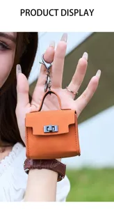 Detailaufnahme der orangefarbenen Mini-Ledertasche als praktischer Schlüsselanhänger.