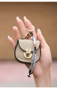 Vista dettagliata del mini portachiavi a borsa sella in pelle con eleganti dettagli dorati.