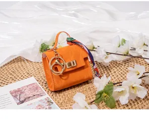 Oranger kleiner Taschenanhänger mit Metallteilen und Seidenschal für den Schlüssel.