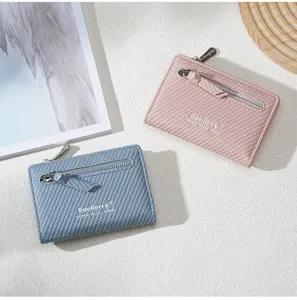 Detail shot of stylish women's short zipper wallets in pink and blue colors with textured finish.