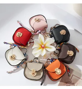 Dettaglio portachiavi borsa sella mini, ciondolo in pelle multicolore con foulard.