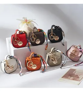 Primo piano di colorati portachiavi a mini borsa a sella, graziosi portamonete e ciondoli.