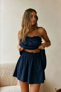 Detail view of the deep blue strapless top and skirt set, showing soft fabric and ruffles.