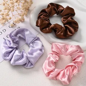 Detailopname van zachte satijnen haarelastiekjes in verschillende kleuren, elegante haaraccessoires.