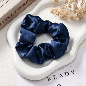 Detailopname van donkerblauwe satijnen haarelastiek, glanzend en elegant haaraccessoire.