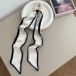 Elegant black and white silk scrunchie with long ribbons for chic ponytail hairstyles.