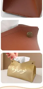 Leather tissue box detail showing premium material, metallic snap button and gold stamping text.