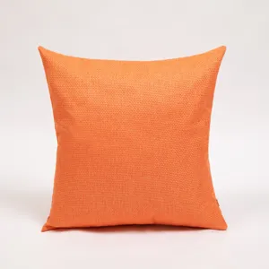 Moderne minimalistische getextureerde linnen kussensloop detail, effen oranje vierkant kussen.