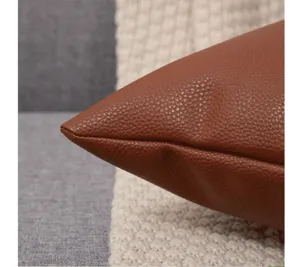 Primer plano de cojín de cuero sintético marrón, textura de funda patrón litchi.