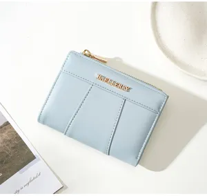 Detailed view of minimalist light blue PU leather short wallet with card slots and zipper.