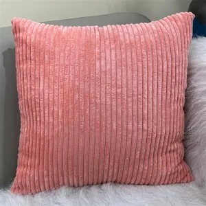 Dettaglio di un cuscino quadrato in velluto a coste rosa con comoda trama a coste morbida.
